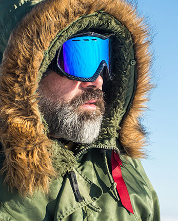 Man in winter coat and tinted ski goggles