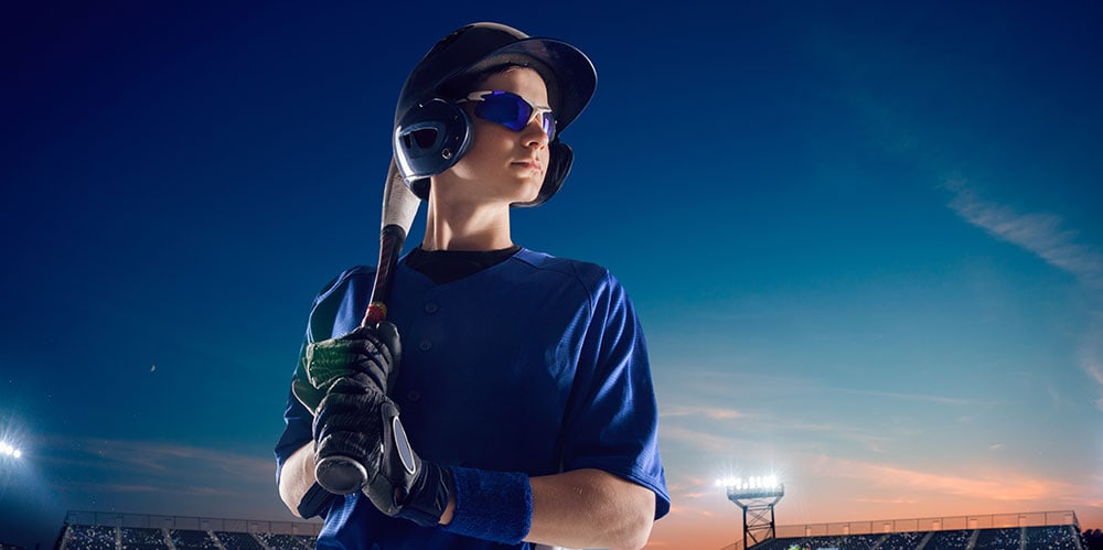 Boy holding baseball bat and wearing protective glasses
