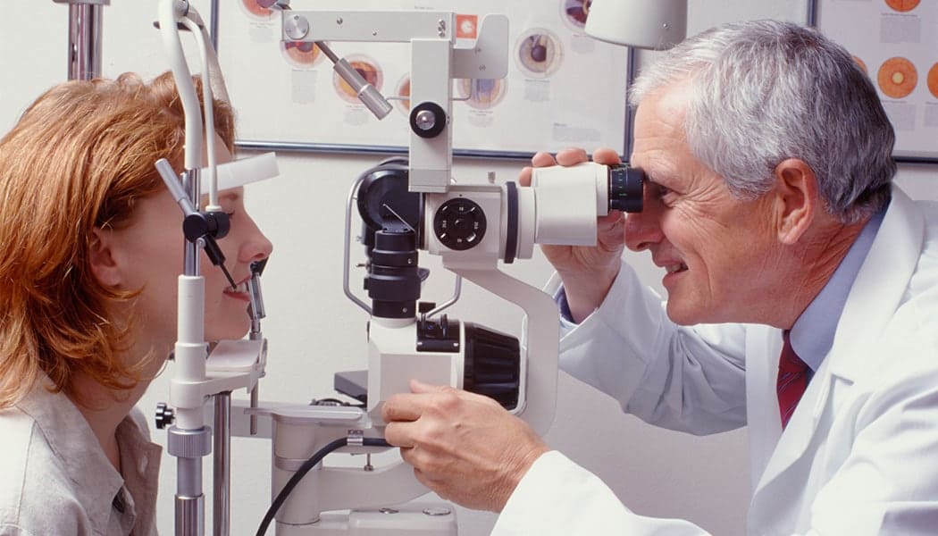 Eye care specialist performing detailed eye examination.