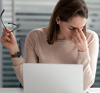 Woman with dry eyes in front of computer