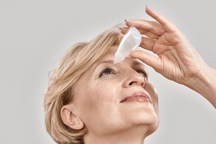 Woman applying eye drops