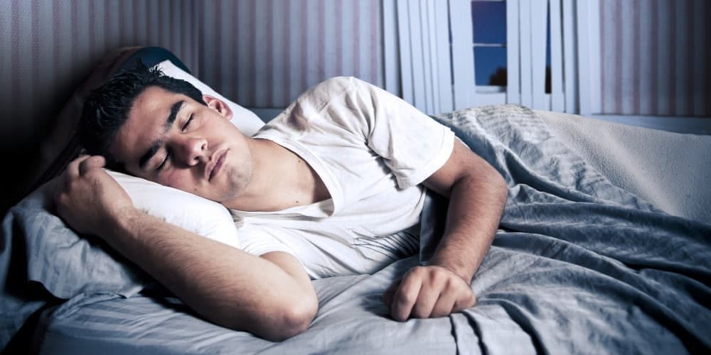 Young man sleeping peacefully in bed.