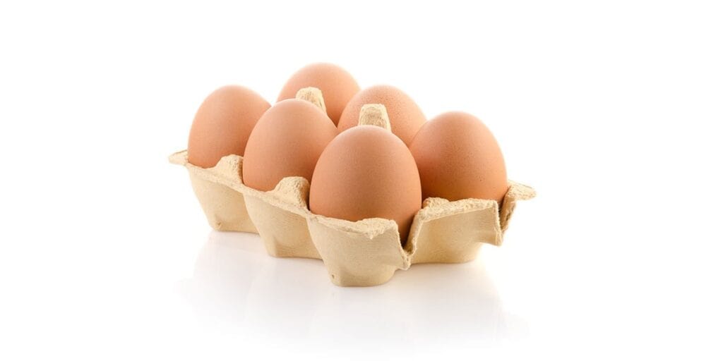 Close-up of fresh eggs in a cardboard egg carton, emphasizing natural food and health aspects.