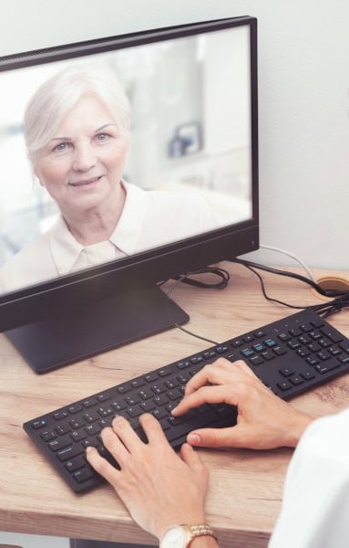 Close-up of a woman receiving an eye consultation via telemedicine on a computer screen, emphasizing advanced eye care and tele-ophthalmology services.