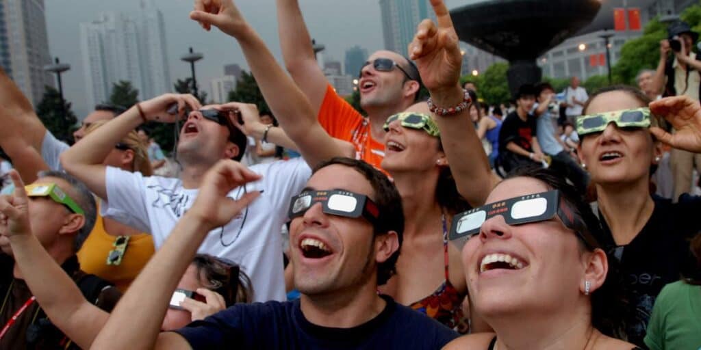 People wearing eclipse glasses enjoying solar eclipse event at Assil Gaur Eye Institute.