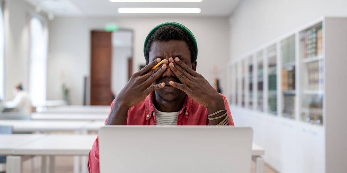 A young man experiencing eye strain at the Assil Gaur Eye Institute, a top destination for comprehensive eye care and vision correction.