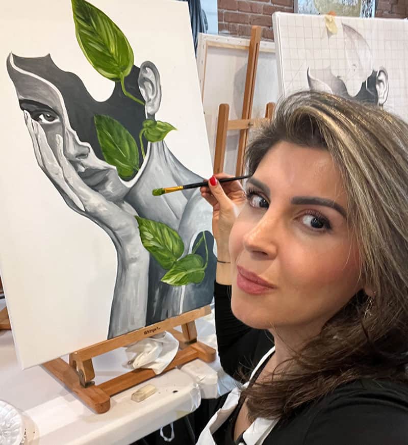 Portrait of a woman painted by Dr. Adele of Asil Gaur Eye Institute with leaves integrated into her face, showcasing artistic creativity..