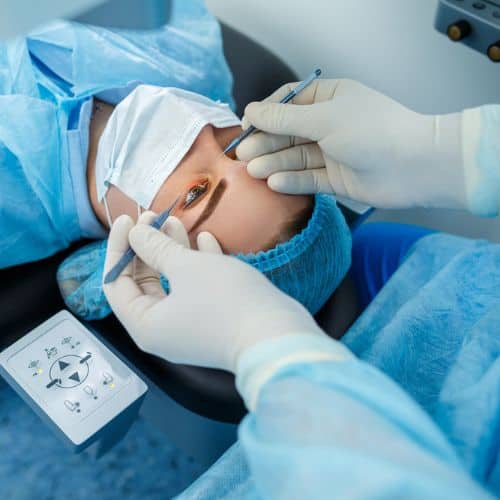 Surgeon performing LASIK eye surgery on a patient in an operating room.